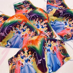 May include: A set of five face masks featuring a colourful print of Disney princesses. The masks are made of a soft, breathable fabric and have adjustable ear loops.
