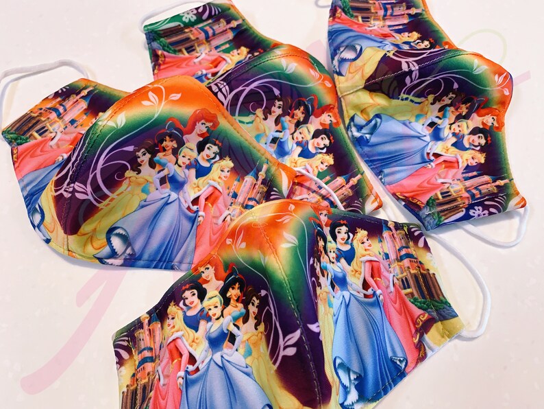 May include: A set of five face masks featuring a colourful print of Disney princesses. The masks are made of a soft, breathable fabric and have adjustable ear loops.