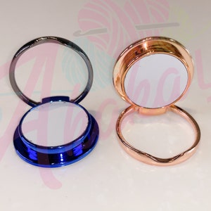 May include: Two phone ring holders with a white, blank surface for customization. One is blue and the other is rose gold.