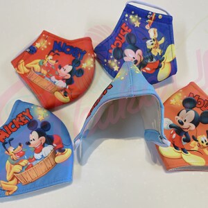 K&ouml;nnte beinhalten: Vier farbenfrohe Gesichtsmasken mit Mickey Mouse und Pluto. Die Masken sind aus Stoff und haben elastische Ohrschlaufen. Die Masken sind mit verschiedenen Designs bedruckt, darunter Mickey Mouse und Pluto in einer Badewanne, Mickey Mouse und Pluto spielen mit Sternen, Mickey Mouse und Pluto spielen mit einem Ball und Mickey Mouse und Pluto spielen mit einem Flugzeug.