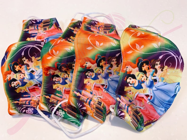 May include: Five colourful face masks featuring a pattern of Disney princesses, including Cinderella, Snow White, and Ariel. The masks have a white elastic band for wearing.