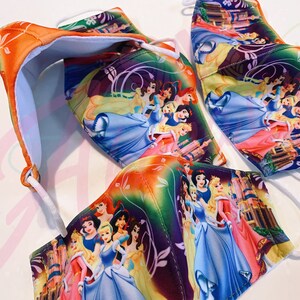 May include: Three colourful face masks featuring a variety of Disney princesses. The masks are made of a soft, breathable fabric and have adjustable ear loops. The princesses are depicted in a whimsical setting with castles and flowers.