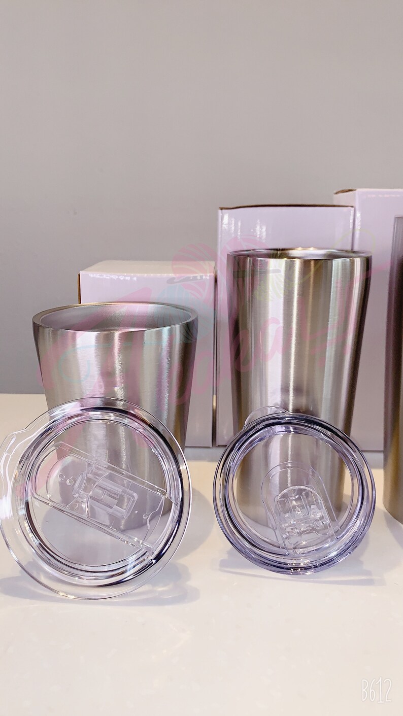 Puede incluir: Dos vasos de acero inoxidable con tapas. Los vasos son plateados y tienen un acabado cepillado. Las tapas son de pl&aacute;stico transparente con un sello de silicona.
