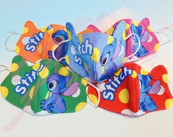 May include: Five colorful face masks with a cartoon Stitch design and white polka dots. Each mask has the word "Stitch" written on it.