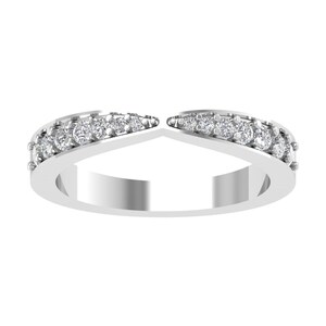 Puede incluir: Un anillo plateado con un diseño curvo. El anillo presenta una fila de pequeñas gemas redondas y transparentes a lo largo de los bordes superiores. El anillo tiene un hueco en el centro, creando un diseño único y abierto.