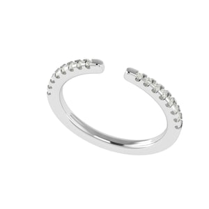 Puede incluir: Un anillo abierto de color plateado con una fila de pequeñas piedras preciosas transparentes engastadas a lo largo de la mitad superior de la banda. El anillo tiene un hueco en la parte superior, creando un diseño abierto. El anillo está sobre un fondo blanco.