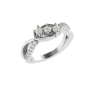 Puede incluir: Un anillo de plata con tres diamantes centrales y diamantes más pequeños engastados a lo largo de la banda. El anillo presenta un diseño en espiral, con los diamantes colocados en una fila en la parte superior. El anillo está sobre un fondo blanco.