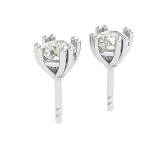 Könnte beinhalten: Ein Paar Ohrstecker mit einem runden, klaren Edelstein, der in einer silberfarbenen, krappengefassten Fassung gefasst ist. Die Ohrringe haben einen Steckerverschluss und werden vor weißem Hintergrund gezeigt.