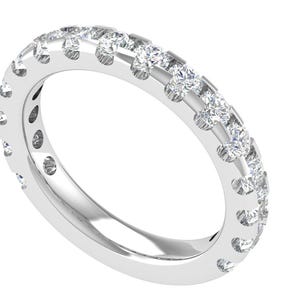 Puede incluir: Un anillo de banda plateado con una fila de pequeñas piedras preciosas claras engastadas en la parte superior. El anillo está muy pulido y refleja la luz, creando un efecto brillante. El anillo está sobre un fondo blanco.