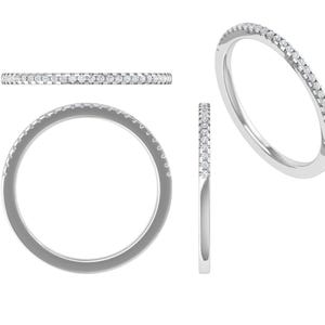 Könnte beinhalten: Ein silberner Ring mit einer Reihe kleiner, klarer Edelsteine. Der Ring wird aus verschiedenen Blickwinkeln gezeigt: von oben, von der Seite und leicht schräg, vor einem weißen Hintergrund. Die Edelsteine sind gleichmäßig angeordnet.