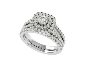 May include: A diamond engagement ring set with a double halo design. The ring features a central round diamond surrounded by two layers of smaller diamonds. The band is also adorned with diamonds, creating a sparkling effect.