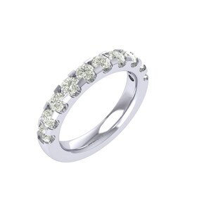 May include: A silver ring with a row of small, round, clear gemstones set along the top. The ring has a polished, reflective surface, and the gemstones are evenly spaced. The ring is set against a white background.