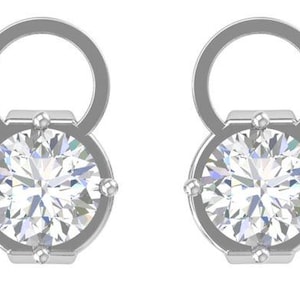 Puede incluir: Un par de pendientes de plata. Cada pendiente presenta una piedra preciosa grande, redonda y transparente engastada en un bisel plateado. Los pendientes tienen un lazo en la parte superior, creando un diseño único.