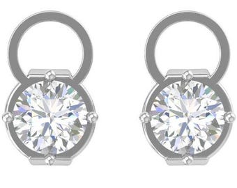 May include: A pair of silver-colored stud earrings. Each earring features a large, round, clear gemstone set in a silver bezel. The earrings have a loop at the top, creating a unique design. The gemstones sparkle brightly against the white background.