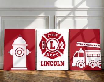 May include: Three rectangular wall art prints featuring fire department themes. The left print shows a white fire hydrant on a red background. The center print displays a red fire department emblem with the letter L and the text FIRE DEPT LINCOLN. The right print depicts a white fire truck on a red background.
