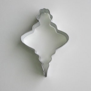 May include: A silver metal cookie cutter shaped like a spinning top or dreidel.