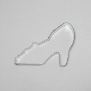 May include: A silver metal cookie cutter shaped like a high-heeled shoe.