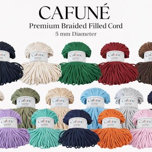 Peut inclure: Une collection de cordons remplis et tressés colorés, chacun emballé et étiqueté avec la marque "CAFUNÉ". L'image présente diverses couleurs, dont le marine, crème, vert, rouge et marron. Le texte indique un diamètre de 5 mm.