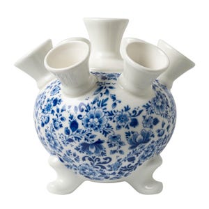 May include: A white ceramic vase with a blue and white floral pattern. The vase has five openings for flowers and sits on three legs.