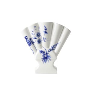 May include: A white ceramic vase with a blue and white floral design. The vase is shaped like a fan and has a wide opening at the top. The floral design includes a monkey and a branch of flowers.