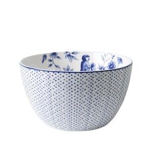 Op de afbeelding: Een witte keramische kom met een blauw en wit bloemenpatroon en een blauw apenontwerp. De kom heeft een witte achtergrond met blauwe stippen.