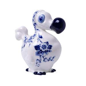 May include: A white ceramic dodo bird figurine with blue and white floral designs. The dodo has a blue beak and blue eyes.