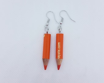 May include: A pair of orange pencil earrings with silver hooks. The pencils have the text "rayola.com" printed on them.