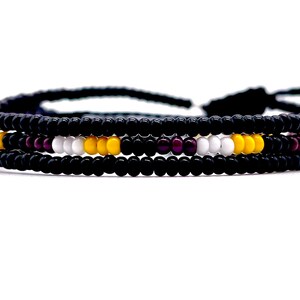 May include: A black beaded bracelet with a single row of white, yellow, and purple beads.