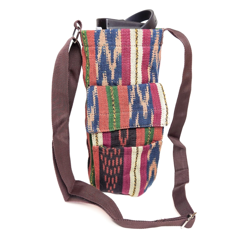 May include: A colorful woven fabric crossbody bag with a brown strap. The bag has multiple pockets and a unique pattern.