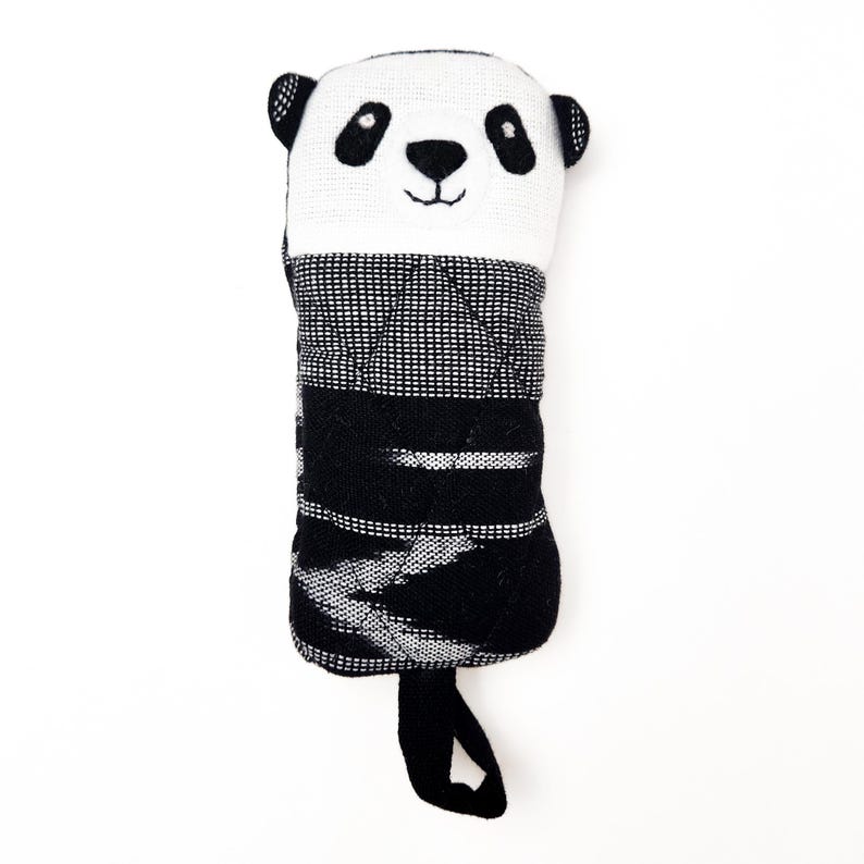 May include: Black and white panda-shaped stuffed toy with a quilted black and white striped body and a black loop handle.