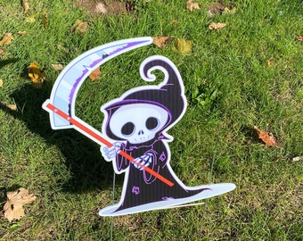 May include: A cartoon Grim Reaper yard decoration with a black robe, purple trim, and a scythe. The decoration is made of cardboard and is designed to be staked into the ground.
