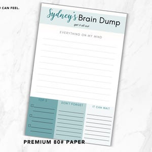 May include: A white notepad with the text "Sydney's Brain Dump" in teal script. The notepad includes sections for "Top 5", "Don't Forget", and "It Can Wait". The notepad is labeled "Premium 80# Paper".