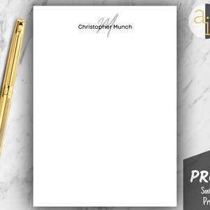 May include: A gold pen rests beside a white sheet of paper with the name "Christopher Munch" printed in gray. The word "PROOF" is visible on a black sign in the lower right corner. A logo is in the upper right corner.