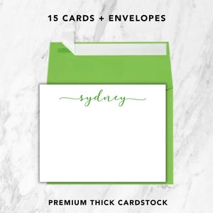 May include: A set of 15 white stationery cards and lime green envelopes. Each card features the name Sydney printed in a green cursive script. The text 15 CARDS + ENVELOPES and PREMIUM THICK CARDSTOCK is visible at the top and bottom of the image.
