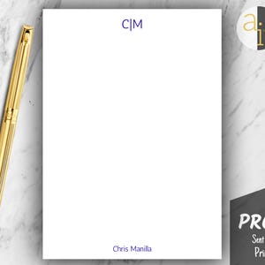 May include: A white notepad with the initials "C|M" in dark blue at the top and the name "Chris Manilla" at the bottom. A gold pen rests on the left side. A "PROOF" stamp is in the bottom right corner.