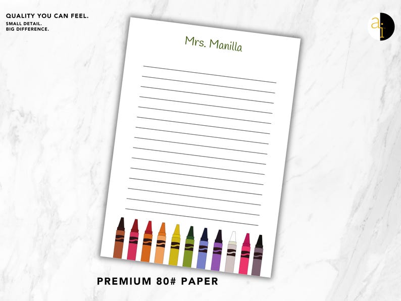 May include: A white lined notepad with the text "Mrs. Manilla" in green. The bottom of the notepad features a row of colorful crayon illustrations. The text "PREMIUM 80# PAPER" is at the bottom. The notepad is on a white marble surface.