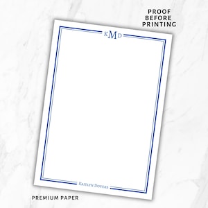 May include: White stationery with a blue border and the initials "KMD" at the top. The text "PROOF BEFORE PRINTING" is at the top, and "KAITLYN DOVERS" and "PREMIUM PAPER" are at the bottom. The paper has a clean, minimalist design.