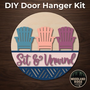Puede incluir: Kit de colgador de puerta DIY con tres sillas Adirondack de madera en azul, coral y morado. La frase "Sit & Unwind" se muestra en el centro, con un diseño geométrico azul marino en la parte inferior. El texto "DIY Door Hanger Kit" está en la parte superior.