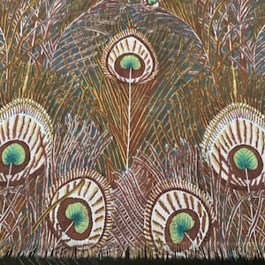 May include: Close-up of a fabric with a repeating peacock feather design. The feathers feature brown, white, and green details against a backdrop of brown and teal. The fabric has a fringed edge.