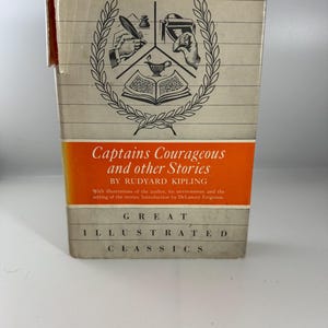 May include: A vintage book cover with a white background and orange accents. The cover features a black and white illustration of a wreath with a quill pen, an inkwell, a printing press, and an open book. The title of the book is "Captains Courageous and other Stories by Rudyard Kipling". The book is part of the "Great Illustrated Classics" series.