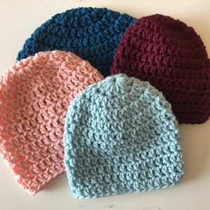 Puede incluir: Cuatro gorros de punto de ganchillo en diferentes colores: rosa, azul claro, azul oscuro y burdeos.