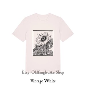 K&ouml;nnte beinhalten: Vintage wei&szlig;es T-Shirt mit einer Schwarz-Wei&szlig;-Sonnenblumen-Illustration in einem rechteckigen Rahmen. Das Shirt hat kurze &Auml;rmel und einen Rundhalsausschnitt. Der Text "Etsy: OldfangledArtShop" und "Vintage White" sind darunter gedruckt.