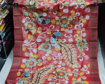 May include: A red silk saree with a floral and peacock design. The saree has a gold border and a white background with colorful details.