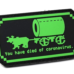 Pode incluir: Patch bordado verde e preto com uma imagem pixelada de uma criatura puxando um rolo de papel higiênico. O texto "You have died of coronavirus." está abaixo da imagem.