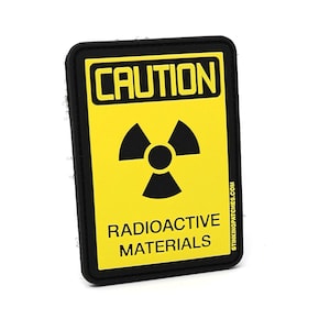 May include: A black and yellow caution sign with a radioactive symbol and the text "CAUTION RADIOACTIVE MATERIALS" on a white background.