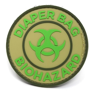 May include: A green and tan round patch with the text "Diaper Bag Biohazard" and a green biohazard symbol in the center. The text "StinkingPatches.com" is printed on the right side of the patch.