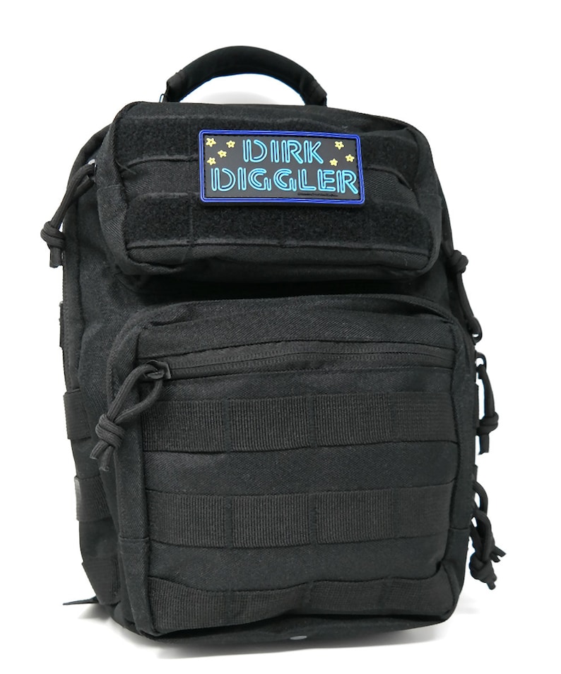 May include: Black tactical backpack with a velcro patch that says "DIRK DIGGLER" in blue and yellow lettering.