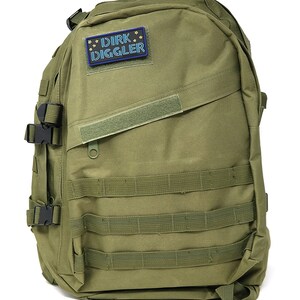 May include: A green military-style backpack with multiple straps and buckles. A patch with the text "DIRK DIGGLER" in blue neon lettering is attached to the front.