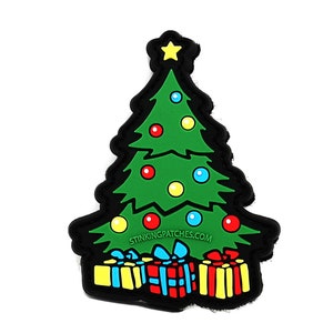 May include: A green Christmas tree with a yellow star on top and colorful ornaments. The tree is surrounded by wrapped presents with red, blue, yellow, and green accents. The text "STINKINGPATCHES.COM" is printed below the tree.
