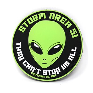 Pode incluir: Um remendo redondo preto e verde com um rosto de alienígena verde no centro. O texto ao redor do alienígena diz "Storm Area 51 They Can't Stop Us All September 20, 2019".